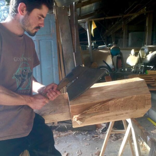 Charles Barbero pratiquant l'équarrissage des grumes sur une pièce de bois